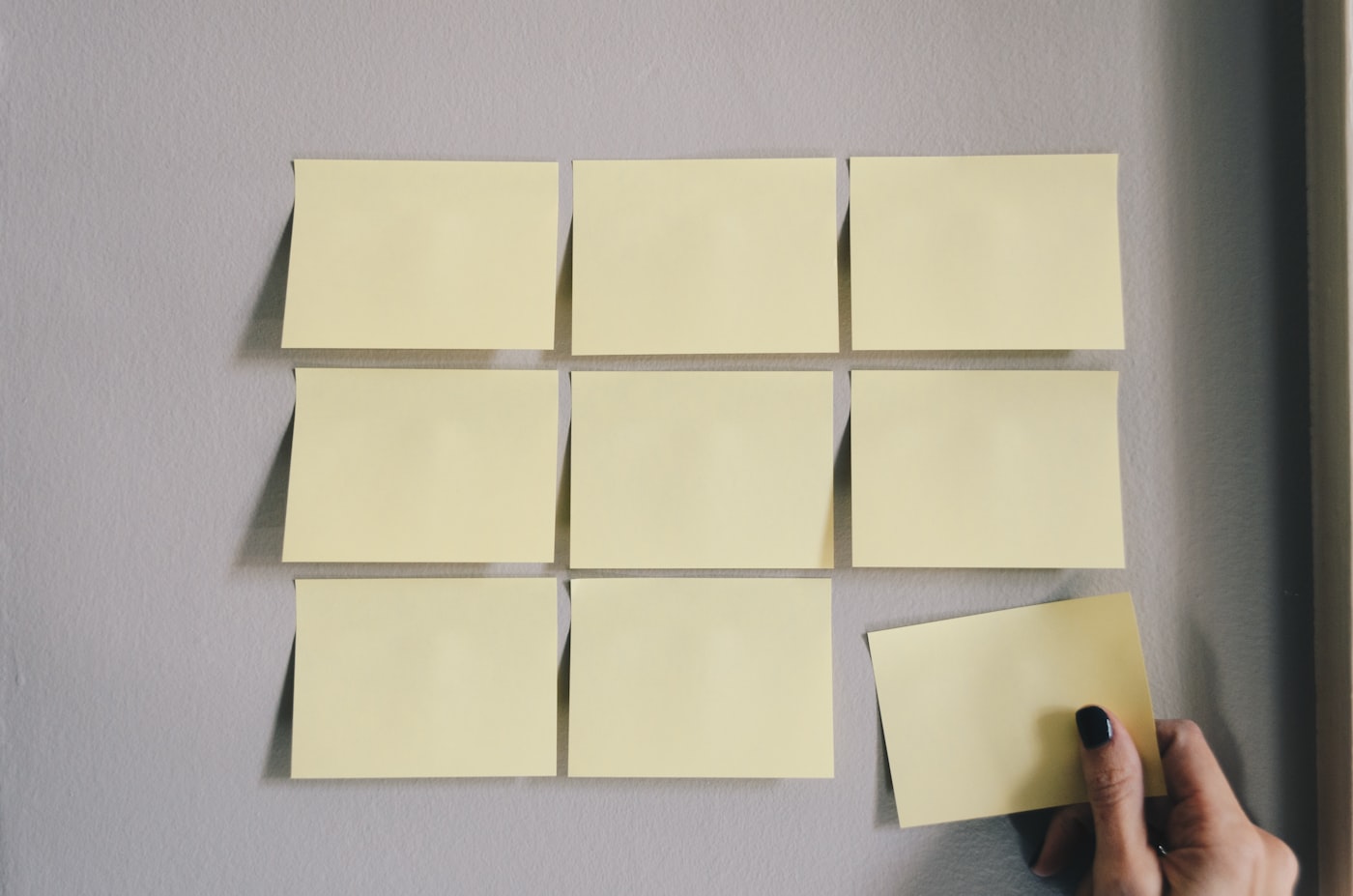 Hand placing one card into a grid of blank cards