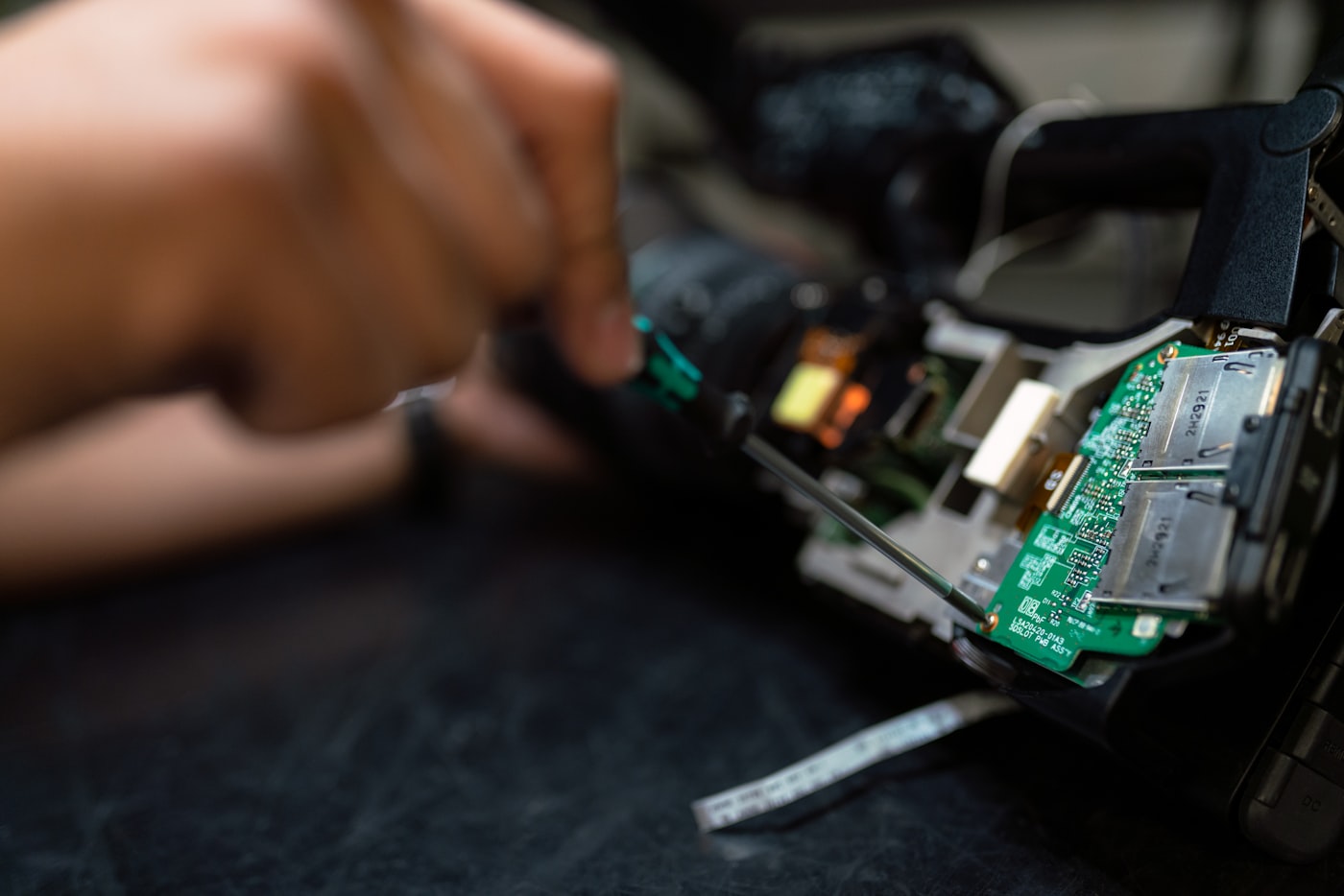 Hands working on an IoT device's electronics